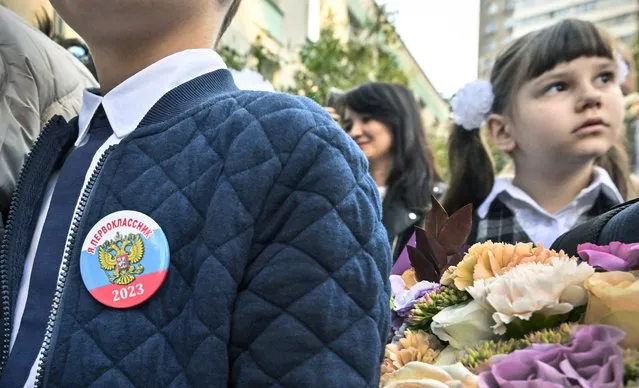 A pin reading “I'm a first grader 2023” adorns the jacket of a schoolboy during a “first bell” ceremony to mark the beginning of the school year in Moscow on September 1, 2023. (Photo by Alexander Nemenov/AFP Photo)