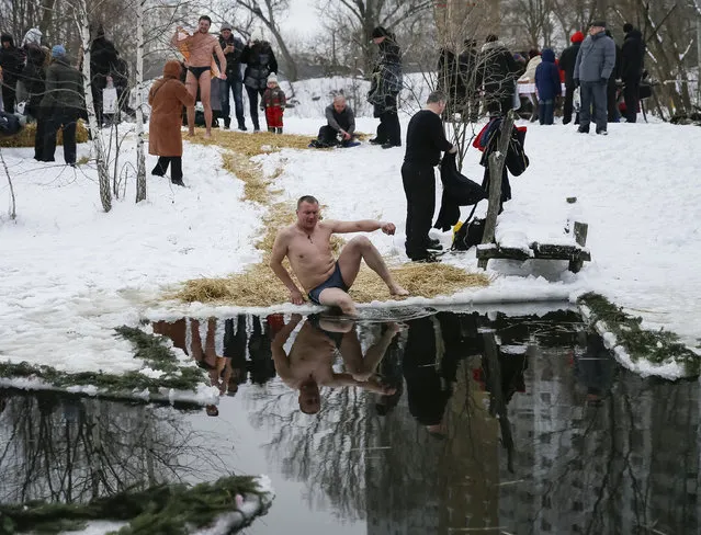 A man takes a dip in a lake during Orthodox Epiphany celebrations in Kiev, Ukraine, January 19, 2016. (Photo by Gleb Garanich/Reuters)