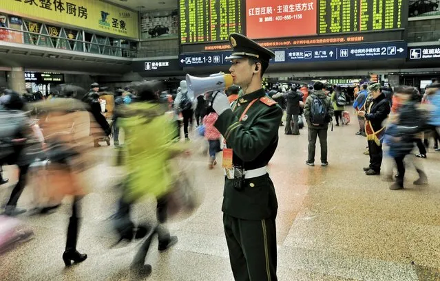 A paramilitary policeman directs passengers at a railway station in Beijing, China, January 30, 2016. According to traffic police, over 2.9 billion trips will be made around China during the 40-day Spring Festival travel rush, which started on January 24. (Photo by Reuters/Stringer)