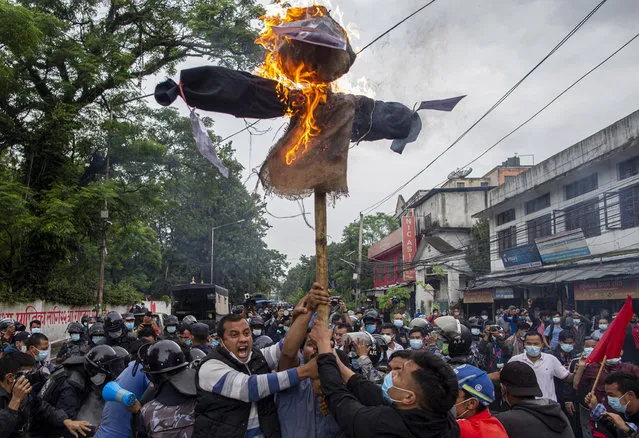 Nepalese protestors affiliated with wings of main opposition political parties burn an effigy of Nepalese president Bidhya Devi Bhandari and Prime Minister K.P. Sharma Oli during an anti-government protest in Kathmandu, Nepal, 01 July 2021. Nepalese student activists protested amidst Coronavirus lockdown, against Prime Minister KP-Oli government's act of dissolving the House of Representatives. (Photo by Narendra Shrestha/EPA/EFE)