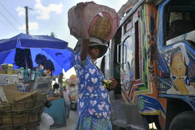 A street vendor hawking bananas waits for customers at a bus terminal in Port-au-Prince, Haiti, Saturday, July 10, 2021, three days after President Jovenel Moise was assassinated in his home. (Photo by Matias Delacroix/AP Photo)
