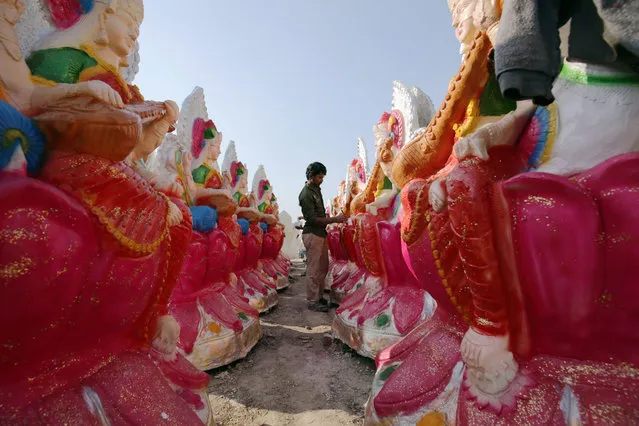 A man paints the idols of Goddess Saraswati, the Hindu deity of knowledge, arts, wisdom and learning, on a roadside workshop in Amritsar, India, 05 February 2016. The idols will be used in worshipping and rituals on the upcoming Basant festival. (Photo by Raminder Pal Singh/EPA)