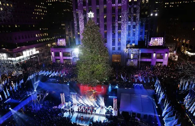 The Rockefeller Center Christmas tree towers over the skating rink in New York. Some 45,000 energy efficient LED lights adorn the 76-foot tree. (Photo by Kathy Willens/Associated Press)