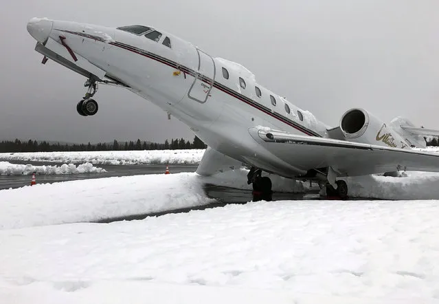 This Wed. January 16, 2019 photo shows an overnight accumulation of about 20 inches of heavy wet snow dubbed “Sierra cement” causing a Cessna Citation X business jet at an outdoor parking spot to do a tail stand at Truckee Tahoe Airport in Truckee, Calif. Airport official Marc Lamb photographed the aircraft before mechanics cleared the snow. No injuries were reported.  (Photo by Marc Lamb via AP Photo)