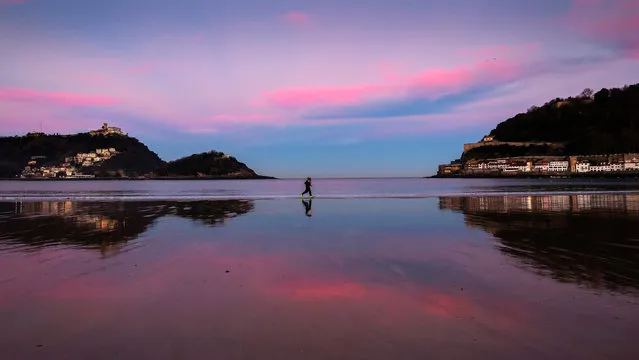 People run during sunrise at La Concha beach in San Sebastian, northern Spain, 28 December 2016. Maximum temperatures will rise up to 17 degrees Celsius in the north of Spain. (Photo by Javier Etxezarreta/EPA)