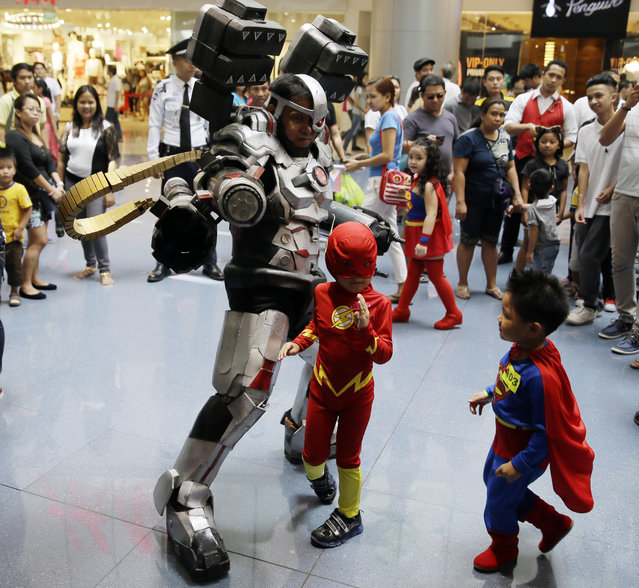 A Filipino fan, in a Cyborg costume, poses with boys dressed as Superman, right, and Flash, during the gathering of DC comics super heroes at the country's largest shopping mall in an attempt to establish a world record for the most number wearing their super heroes costumes Saturday, April 18, 2015 at suburban Quezon city, northeast of Manila, Philippines. (Photo by Bullit Marquez/AP Photo)