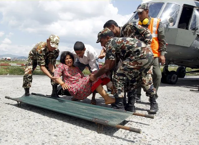 Indian Army soldiers place an injured woman, who was wounded in Saturday's earthquake, on a stretcher after she was evacuated from Trishuli Bazar to the airport in Kathmandu, Nepal, April 27, 2015. (Photo by Jitendra Prakash/Reuters)