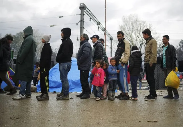 Migrants wait for food in a queue at a makeshift camp on the Greek-Macedonian border near the village of Idomeni, Greece March 10, 2016. (Photo by Stoyan Nenov/Reuters)