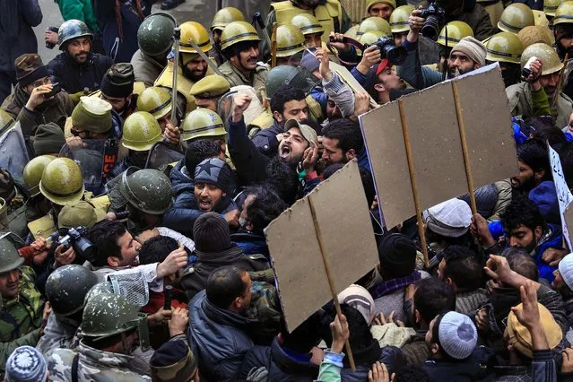 Police prevent Kashmiri Muslim separatist leaders and activists of Jammu Kashmir Liberation Front from proceeding forward during a protest against the Indian army in Srinagar, India, on January 31, 2014. Police fired tear gas to disperse angry protesters who were protesting against the army's decision to close the Pathribal fake encounter case against five soldiers in connection with the killing of five innocent persons in March 2000 in Pathribal, a village that lies south of Kashmir. (Photo by Dar Yasin/Associated Press)