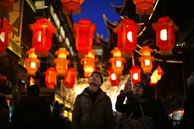 A couple look at Chinese New Year lanterns decorating Yuyuan Garden in downtown Shanghai January 28, 2014. (Photo by Carlos Barria/Reuters)