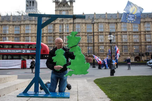 A pro-Brexit protester erects a model of the British Isles hanging from gallows marked with the EU symbol outside the Houses of Parliament on March 25, 2019 in London, England. British Prime Minister Theresa May is facing increased pressure to resign as she continues her attempts to pass a Brexit deal through Parliament. (Photo by Jack Taylor/Getty Images)