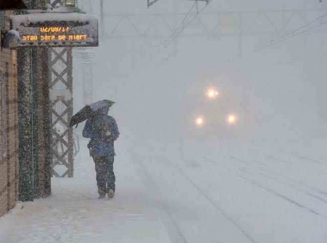 Commuters walk in the snow at the Metro North Greenwich train station on February 9, 2017 as winter storms hit the area in Greenwich, Connecticut. (Photo by Timothy A. Clary/AFP Photo)