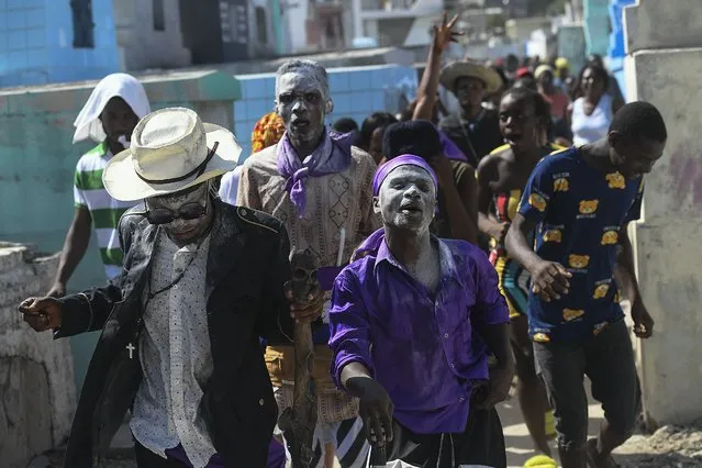 People believed to be possessed with the Gede spirit hold a ceremony honoring the Haitian Vodou spirit of Baron Samedi and Gede at the National Cemetery in Port-au-Prince, Haiti, Monday, November 1 2021. (Photo by Matias Delacroix/AP Photo)