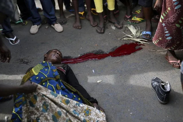 A protester lays dead after being shot in the Kinama district of Bujumbura, Burundi, Thursday May 7, 2015.  Demonstrators protesting against President Pierre Nkurunziza's decision to seek a third term in office clashed with the widely feared pro-government Imbonerakure militias and police, as unrest continues in the Burundi capital. (Photo by Jerome Delay/AP Photo)