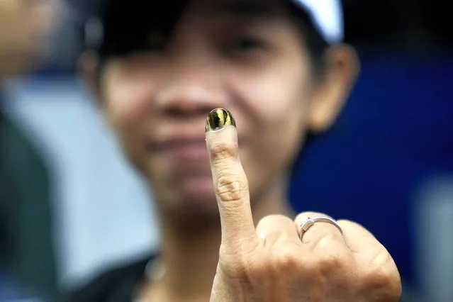 A woman shows her finger inked to mark that she has already voted during the election in Jakarta, Indonesia, Wednesday, February 14, 2024. Millions of Indonesians were choosing a new president Wednesday as the world's third-largest democracy aspires to become a global economic powerhouse just over 25 years since emerging from a brutal authoritarian era. (Photo by Dita Alangkara/AP Photo)