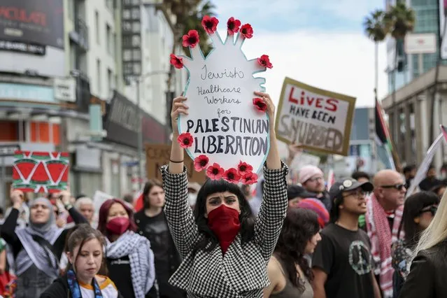 A protester holds a poster during a demonstration in support of Palestinians calling for a ceasefire in Gaza as the 96th Academy Awards Oscars ceremony is held nearby, Sunday, March 10, 2024, in the Hollywood section of Los Angeles. (Photo by Etienne Laurent/AP Photo)
