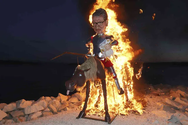 An effigy resembling Serbia's president Aleksander Vucic riding a donkey burns during carnival procession in Kastela, Southern Croatia, Tuesday, February 13, 2024. (Photo by Veljko Martinovic/AP Photo)