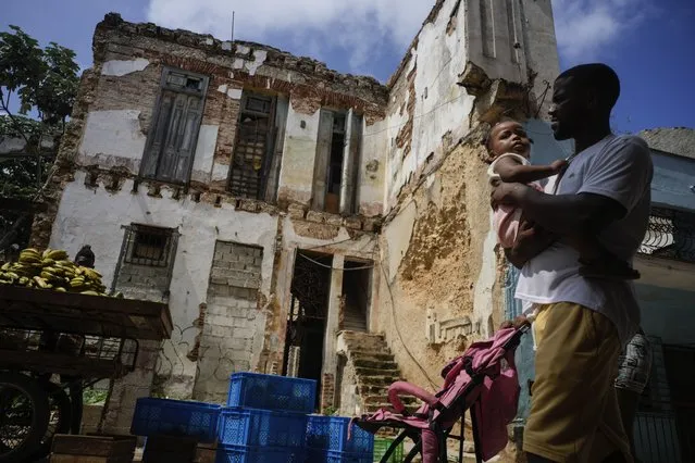 Residents walk past dilapidated mansion on Villegas Street in Havana, Cuba, Thursday, October 5, 2023. The two-story building, which houses six families, is one of many, once luxurious houses that in recent years have partially collapsed or suffered visible damage. (Photo by Ramon Espinosa/AP Photo)
