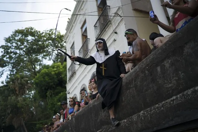 A man dressed as a nun cracks a whip during the Carmelitas street party in Rio de Janeiro, Brazil, Friday, February 24, 2017. (Photo by Leo Correa/AP Photo)