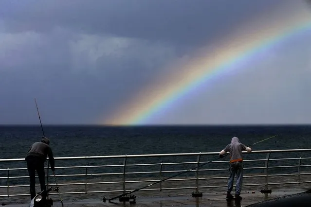Fishermen prepare to fish as a rainbow appears over the Mediterranean Sea in Beirut, Lebanon, Sunday, October 17, 2021. (Photo by Bilal Hussein/AP Photo)
