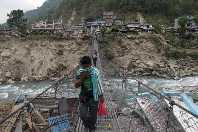 Local residents walk on a bridge, past collapsed buildings, after Tuesday's earthquake at Singati Village, in Dolakha, Nepal, May 15, 2015. (Photo by Athit Perawongmetha/Reuters)