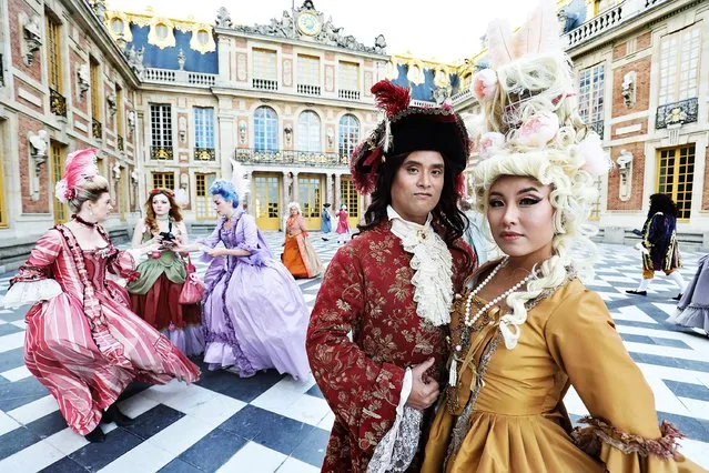 Guests in baroque period costumes pose for a picture at the Chateau de Versailles “Fetes Galantes” masked ball on May 27, 2019, in Versailles, just south west of the French capital Paris. (Photo by Ludovic Marin/AFP Photo)