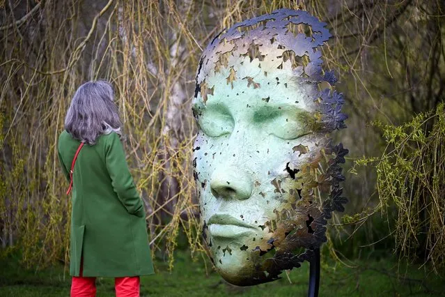 A woman poses by “Leaf Spirit” by Simon Gudgeon at the FORM 24 show at Sculpture by the Lakes, on April 02, 2024 in Dorchester, England. The award-winning sculpture show runs from April 2 to June 1, with works by more than 35 leading contemporary sculptors exhibited throughout 26-acres of lakes, rivers, gardens, and woodlands as well as in the Gallery and The Retreat. FORM includes a series of talks and events to accompany the exhibition, including “Meet the Artist” Q&A sessions with exhibiting sculptors, workshops and demonstrations. (Photo by Finnbarr Webster/Getty Images)