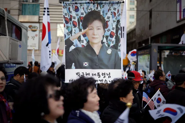 Supporters of South Korean President Park Geun-hye holding national flag Taegeukgi attend a protest called “Taegeukgi protest” near the Constitutional Court, a day before South Korea's Constitutional Court ruling on President Park Geun-hye's impeachment, in Seoul, South Korea, March 9, 2017. (Photo by Kim Hong-Ji/Reuters)