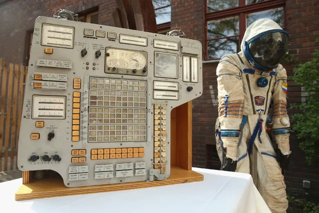 An original instrument panel from the Vozvrashchayemyi Apparat (VA) former Soviet space capsule and a Sokol KV2 spacesuit stand on display during a press preview before the auction of the capsule on April 3, 2014 in Berlin, Germany. The capsule, which could carry three astronauts, served on two Cosmos space missions in the late 1970s. It will be on display in Berlin from April 4–7 and is scheduled to be sold at auction in Brussels on May 7. (Photo by Sean Gallup/Getty Images)