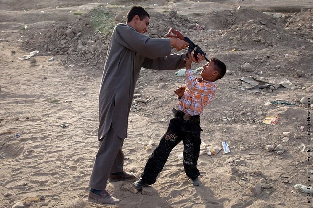 Afghan boys play with their new toy guns on the streets
