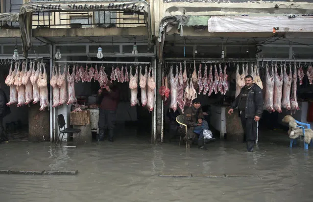 Afghan butchers wait for the customers while water enters into their shops, after few days rainstorm in Kabul, Afghanistan, Saturday, April 2, 2016. Kabul Afghanistan's major cities do not have canalization system for rain and flood water. (Photo by Massoud Hossaini/AP Photos)