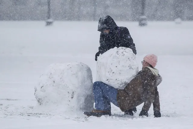 Two women work to build a snowman on the Boston Common walk through the Boston Common as Winter Storm Stella bears down on March 14, 2017 in Boston, Massachussets. (Photo by Scott Eisen/Getty Images)