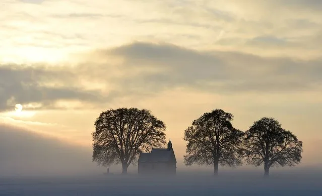 Fog surrounds a small church not far from the small Bavarian village Apfeltrach near Landsberg, southern Germany, during a cold winter morning with temperatures of minus five degrees on January 3, 2017. (Photo by Christof Stache/AFP Photo)