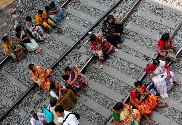 People sit on railway tracks in Kolkata, India, March 24, 2017. (Photo by Rupak De Chowdhuri/Reuters)