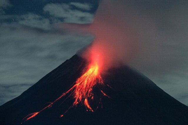 Mount Merapi spews lava onto its slopes during an eruption before dawn as seen from Kaliurang Selatan, central Java on July 7, 2024. (Photo by Devi Rahman/AFP Photo)