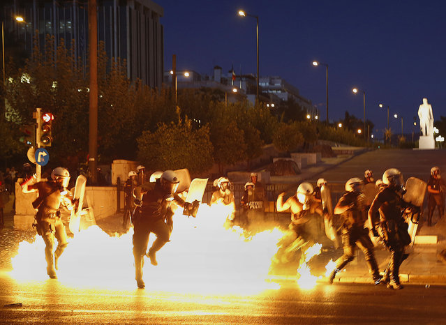 Riot policemen try to avoid an exploding petrol bomb during clashes in Athens, Greece July 15, 2015. (Photo by Yannis Behrakis/Reuters)