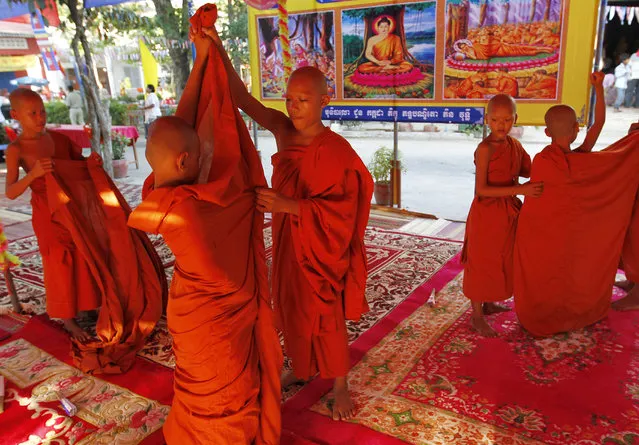 Young Cambodian Buddhist monks wear their clothes during Visaka Bochea celebration at a pagoda in Takeo province, Cambodia, May 13, 2014. Visaka Bochea is a celebration that commemorates Buddha's birth enlightenment death and his passing into nirvana. (Photo by Mak Remissa/EPA)