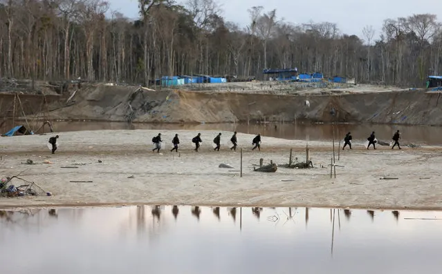Peruvian police officers take part in an operation to destroy illegal gold mining camps in a zone known as Mega 14, in the southern Amazon region of Madre de Dios July 13, 2015. (Photo by Janine Costa/Reuters)