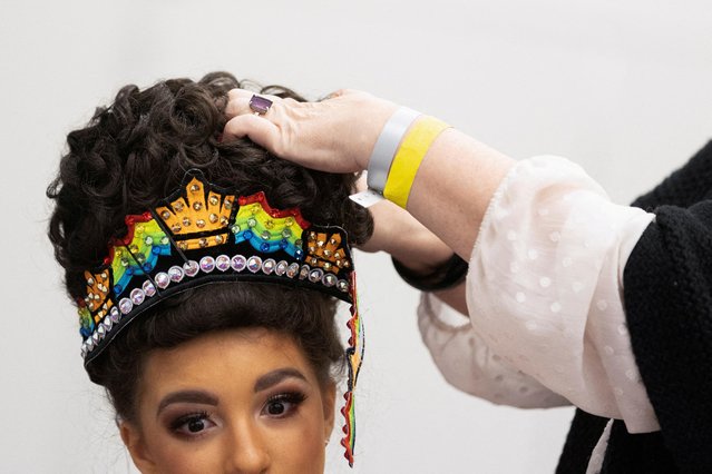 Eliza Jose of Doherty Petri School of Irish Dancing in New York has her hair fixed prior to her performance at the World Irish Dancing Championship in Montreal, Quebec, Canada on April 2, 2023. (Photo by Christinne Muschi/Reuters)