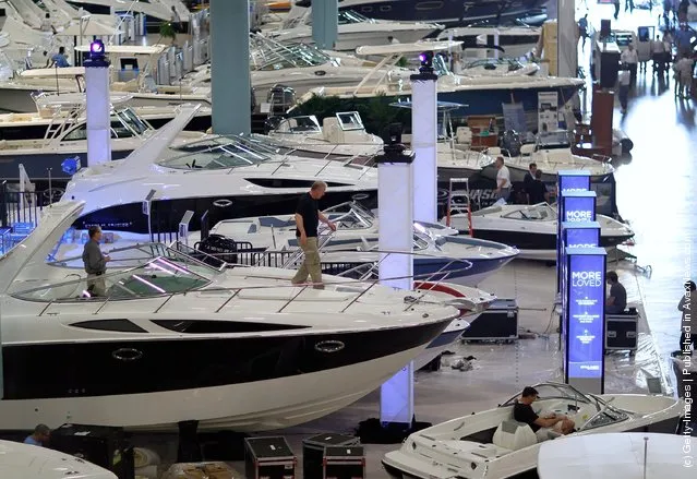 Workers prepare boats for tomorrow's opening day of the four day long Progressive Insurance Miami International Boat Show at the Miami Beach Convention Center