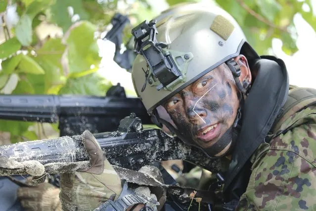 A Japanese soldier takes part in an amphibious drill as part of joint military exercises between the U.S., Japan, France and U.K., Saturday, May 13, 2017, on Naval Base Guam. The military drills in the remote U.S. Pacific islands went ahead as scheduled Saturday, one day after being suspended when a French landing craft ran aground. The exercises feature two French ships currently on a four-month deployment to the Indian and Pacific oceans. (Photo by Haven Daley/AP Photo)