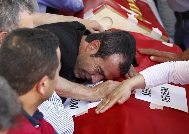 Relatives of victims who were killed in Monday's bomb attack in Suruc mourn over the coffins at a cemetery in Gaziantep, Turkey, July 21, 2015. Turkey's Prime Minister Ahmet Davutoglu rejected accusations Turkey had in the past tacitly supported Islamic State militants operating from Syria and unwittingly opened the door to a suicide bombing that killed at least 32 people. (Photo by Reuters/Stringer)