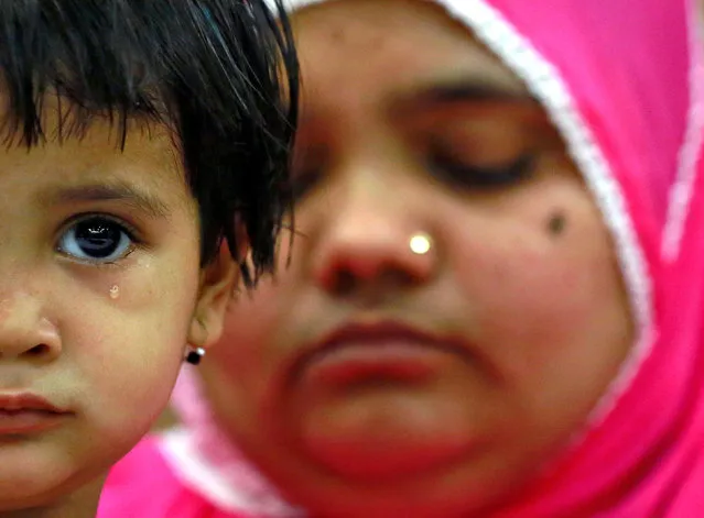 Aksha Yakub Rasool, 2, sits on her mother Bilkis Bano's (R) knee during a press conference in New Delhi, India May 8, 2017. Bilkis was gang raped and fourteen of her relatives, including her three-year-old daughter, were killed during religious riots that broke out in Gujarat in 2002. Last week a court in Mumbai upheld the conviction of 11 men to life in prison for the rape and murder. (Photo by Cathal McNaughton/Reuters)