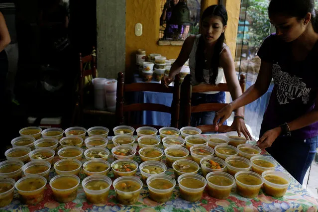 Volunteers of the Make The Difference (Haz La Diferencia) charity initiative serve cups of soup to be donated, at the home kitchen of one of the volunteers in Caracas, Venezuela March 5, 2017. According to a recent study by three Venezuelan universities, 93 percent of the OPEC nation's residents do not have enough money to buy sufficient food and 74 percent have lost around 18 pounds (8 kg) in the last year alone. (Photo by Marco Bello/Reuters)