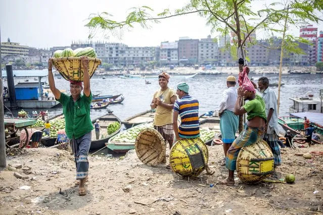 Bangladeshi laborers unload watermelons form a boat at the Buriganga River in Dhaka, Bangladesh, 11 April 2022. Watermelon is in season and is filling the city markets as it arrives from southern Bangladesh. (Photo by Monirul Alam/EPA/EFE)