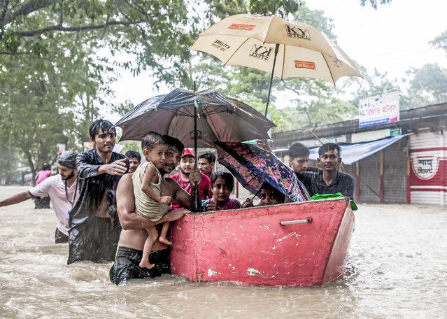 Volunteers rescue women and children trapped in the flood after floods hit the south-eastern city of Feni, Bangladesh on August 23, 2024. Floods triggered by torrential rains have swamped a swath of low-lying Bangladesh, disaster officials said on August 22, adding to the new government's challenges after weeks of political turmoil. (Photo by Muhammad Amdad Hossain/Solent News)