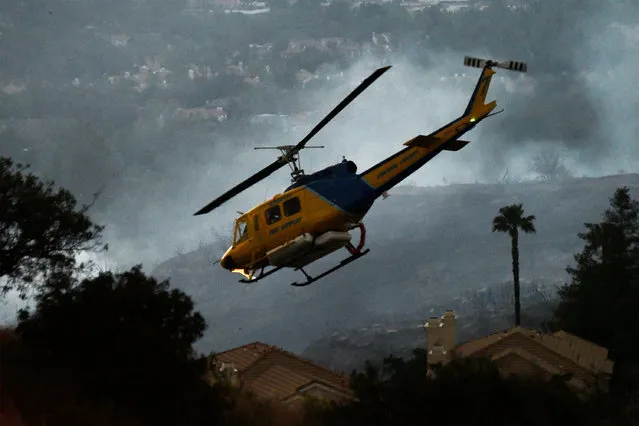 A helicopter makes a water drop run at the “Old Fire”, which burned in Calabasas, California, U.S., June 4, 2016. (Photo by Gene Blevins/Reuters)