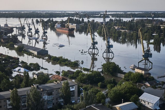 Streets are flooded in Kherson, Ukraine, Wednesday, June 7, 2023 after the walls of the Kakhovka dam collapsed. Residents of southern Ukraine, some who spent the night on rooftops, braced for a second day of swelling floodwaters on Wednesday as authorities warned that a Dnieper River dam breach would continue to unleash pent-up waters from a giant reservoir. (Photo by Libkos/AP Photo)