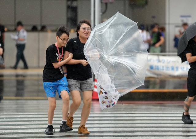 Pedestrians using umbrellas struggle against rain and strong wind in Tokyo, Japan, 16 August 2024, as typhoon Ampil is approaching. The typhoon is approaching to Kanto Tokyo area and Japan's Meteorological Agency has issued heavy rain warning. The powerful typhoon forces to suspend JR Tokaido Shinkansen bullet train service operated by JR Central Japan Company all day between Tokyo and Nagoya, central Japan, and cancel over 600 flights. (Photo by Kimimasa Mayama/EPA/EFE)