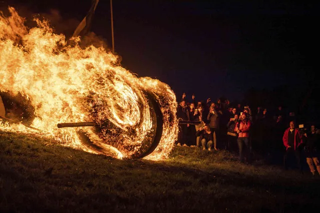 A burning Easter wheel “runs” down the hill in L'gde, North Rhine-Westphalia, Germany. When it is dark the straw in the wheels is lit and the wheels are pushed down the hill. The custom in L'gde is listed as an intangible cultural heritage of Germany by UNESCO. (Photo by Lino Mirgeler/dpa via AP Photo)